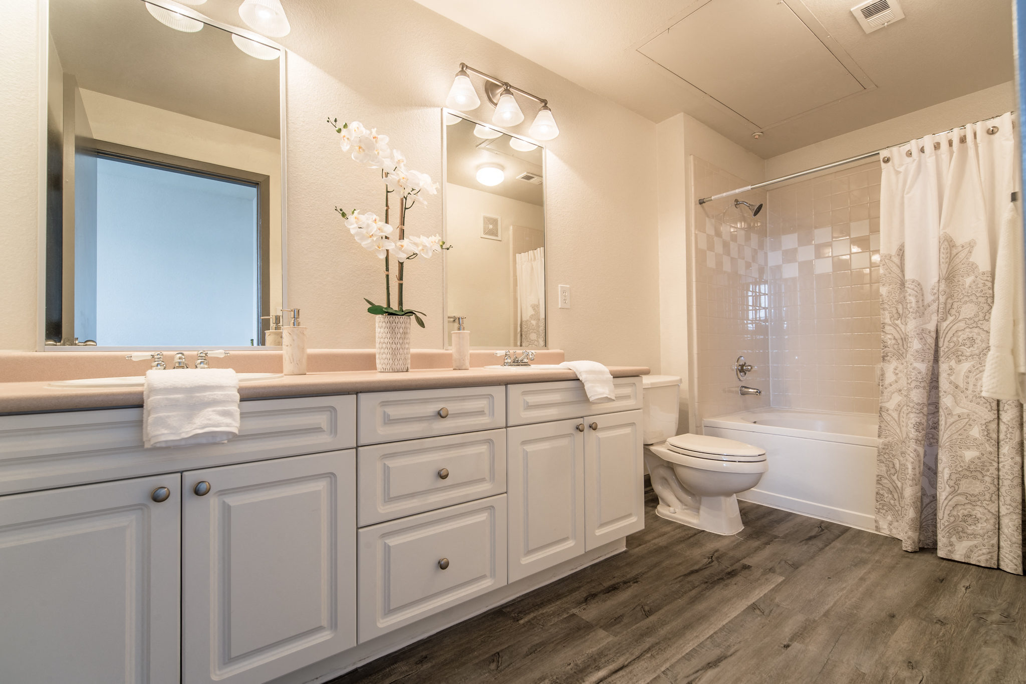 a bathroom with white cabinets and a white toilet and a shower