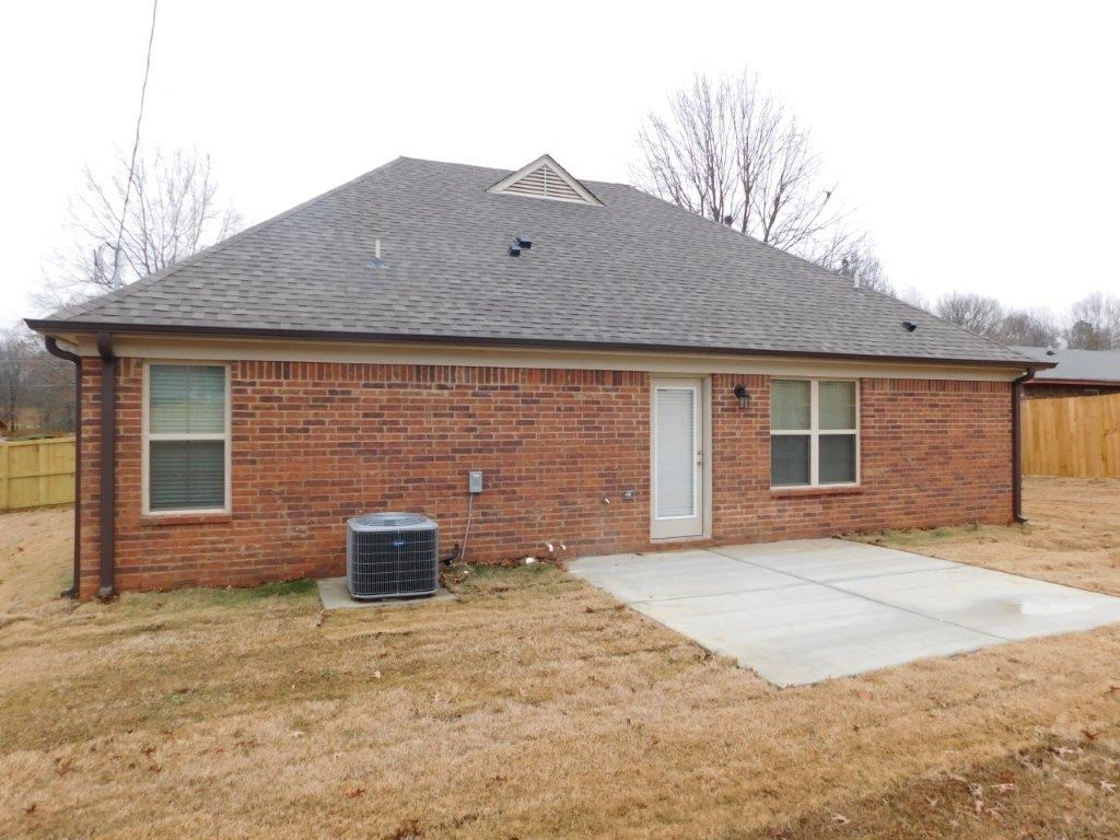 a small brick house with a porch and a driveway