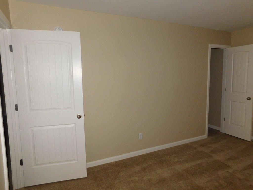 an empty room with a door and a closet