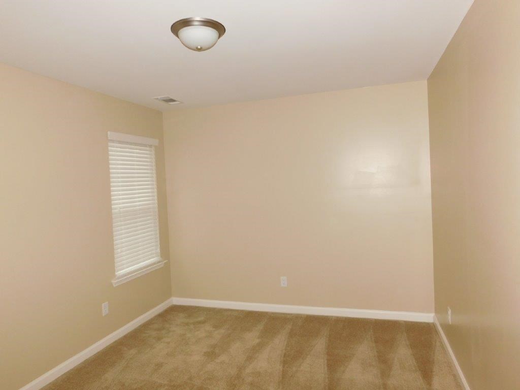 a empty room with a carpeted floor and a ceiling light