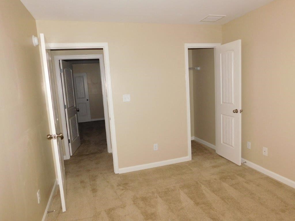 an empty room with a hallway and two doors