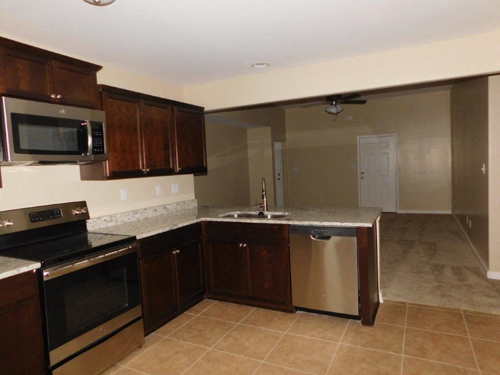 a kitchen with a sink and a stove and a microwave