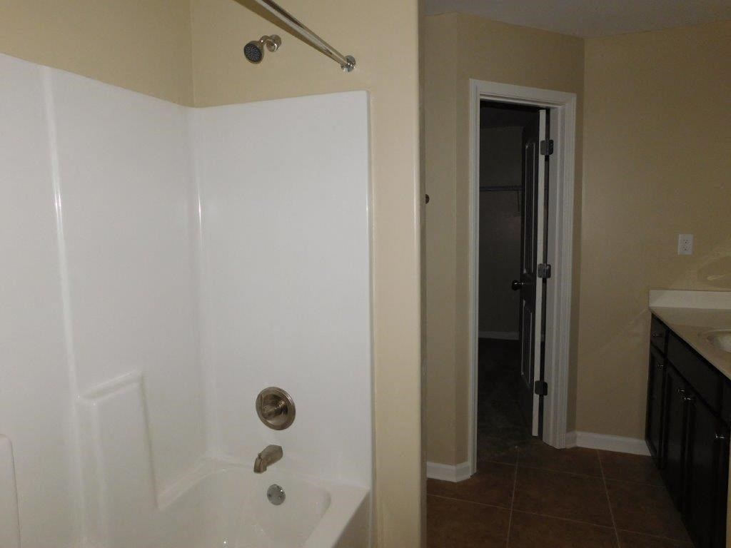 an empty bathroom with a shower and a sink