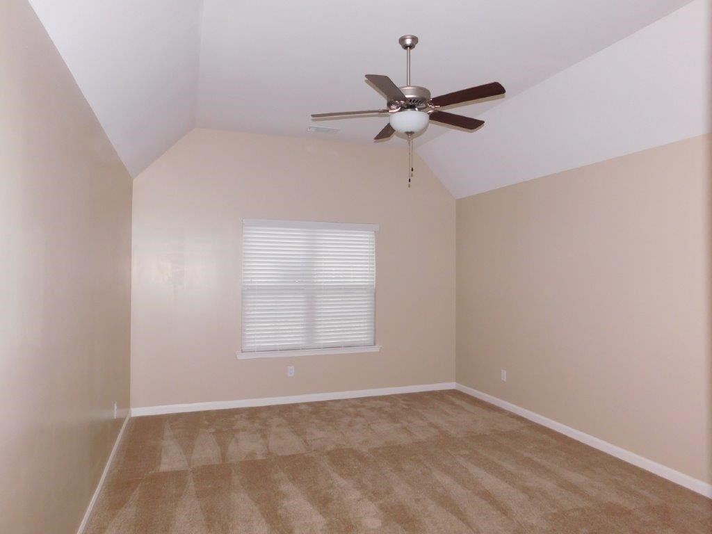 an empty room with a ceiling fan and a window