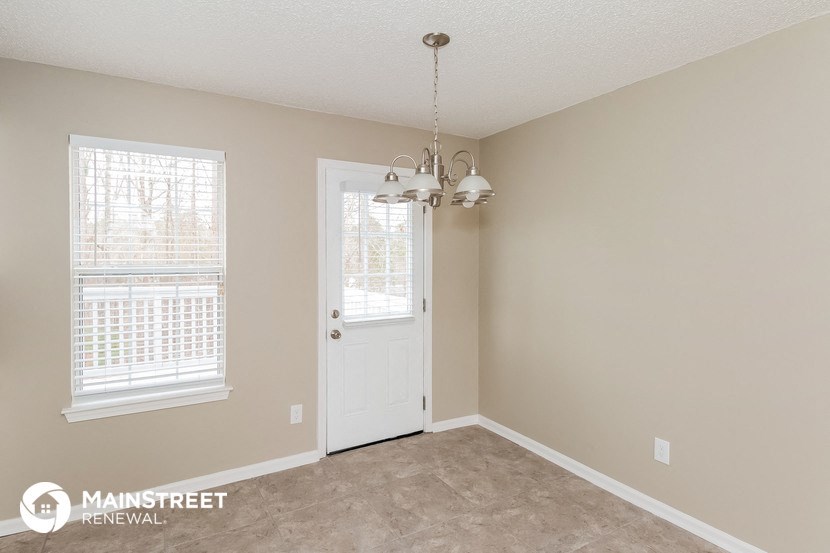 the living room of a home with a door and a chandelier