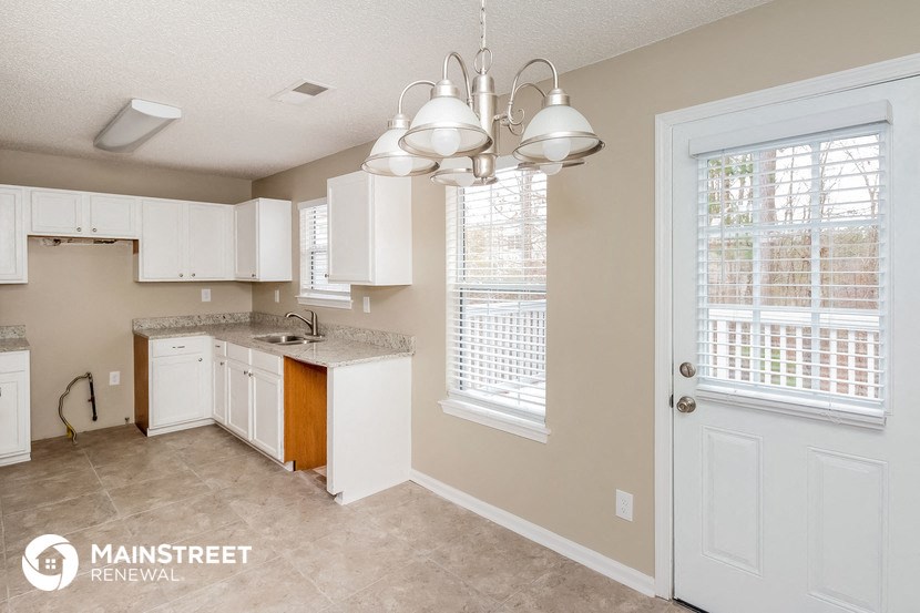 a kitchen with white cabinets and a sink and a door
