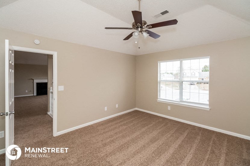 the living room of an empty house with a ceiling fan