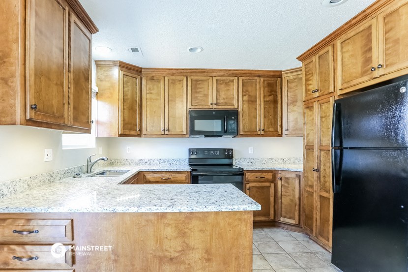 a kitchen with wooden cabinets and black appliances