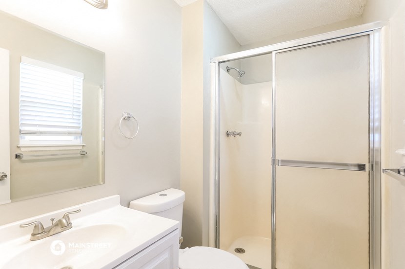 a white bathroom with a shower toilet and sink