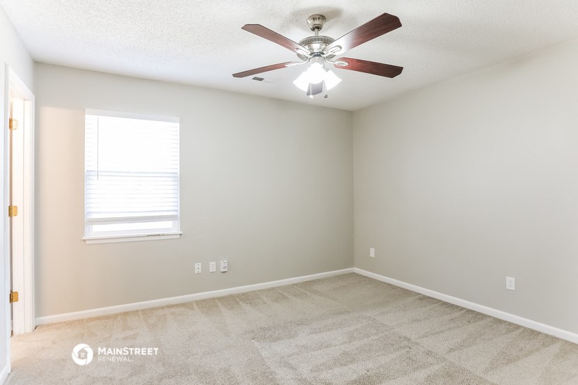 a bedroom with a ceiling fan and a window