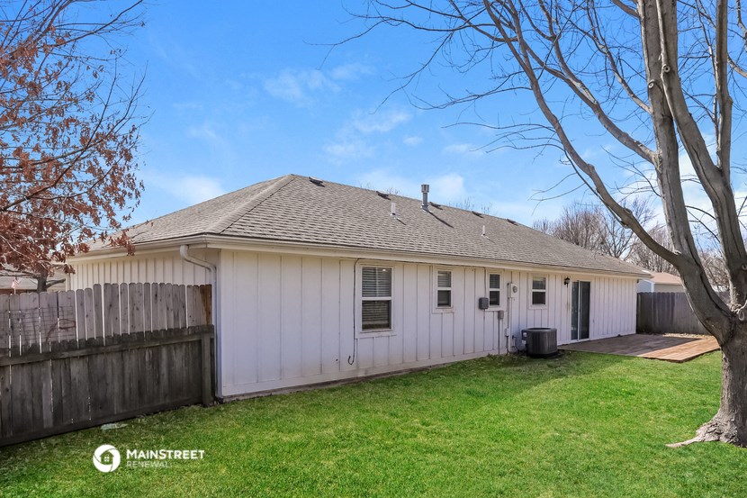 a white house with a yard and a wooden fence