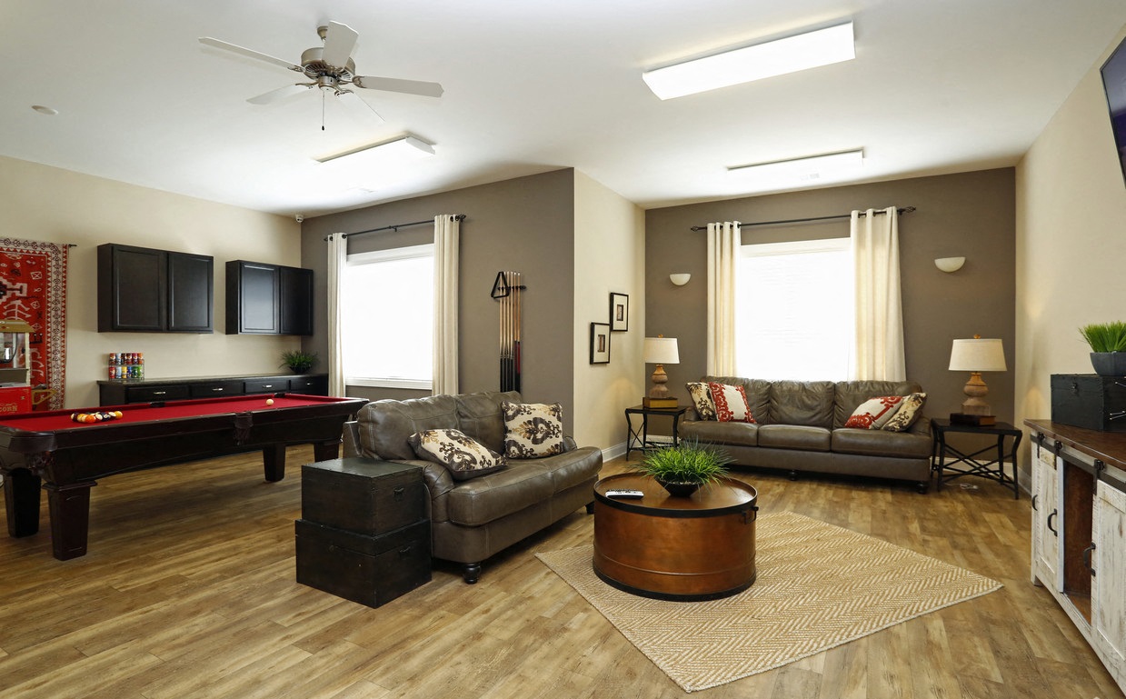 a living room with a pool table and a tv