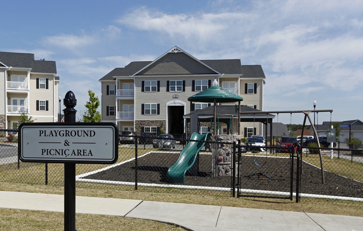 a playground with a slide in front of an apartment building