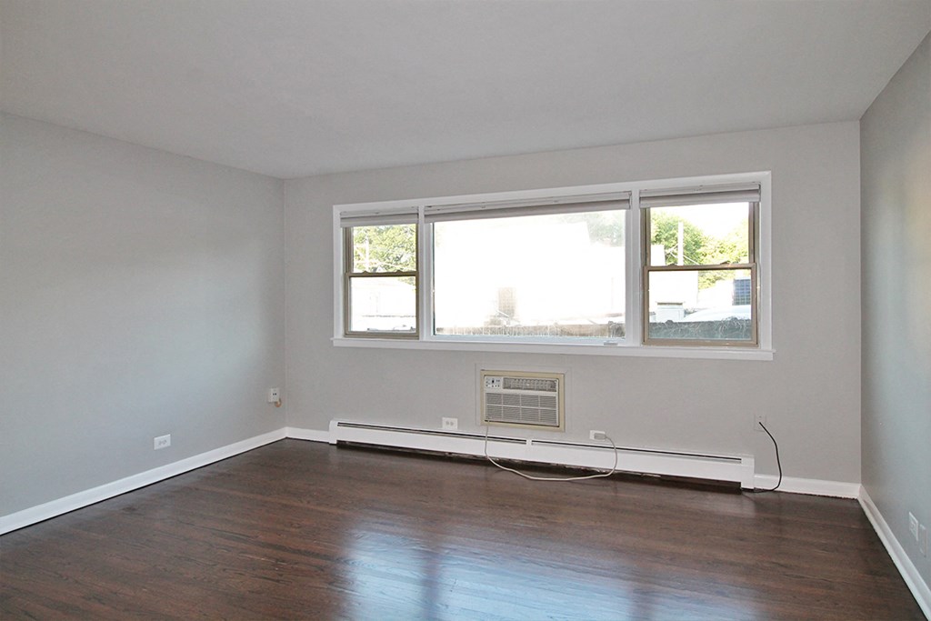 an empty room with wooden floors and a window