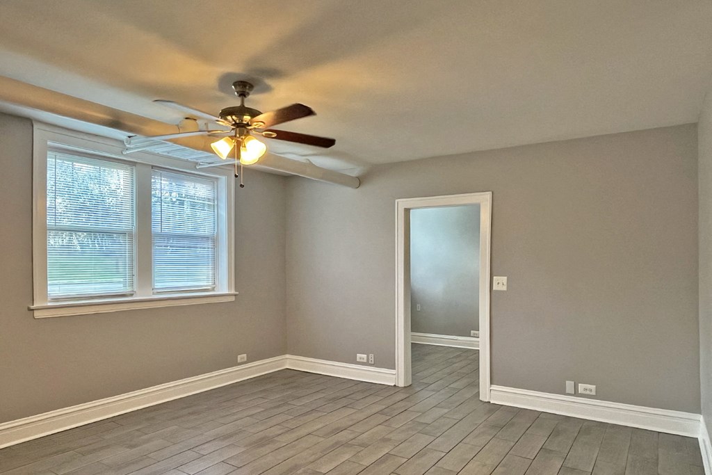 A room with a ceiling fan and a window.