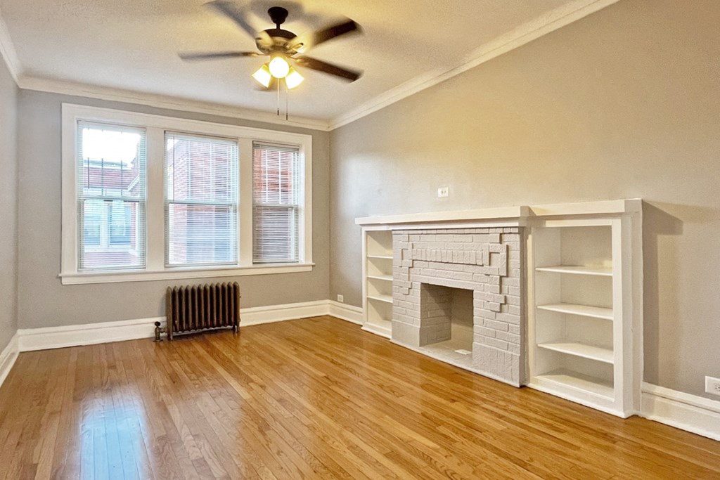 A room with a fireplace and a ceiling fan.