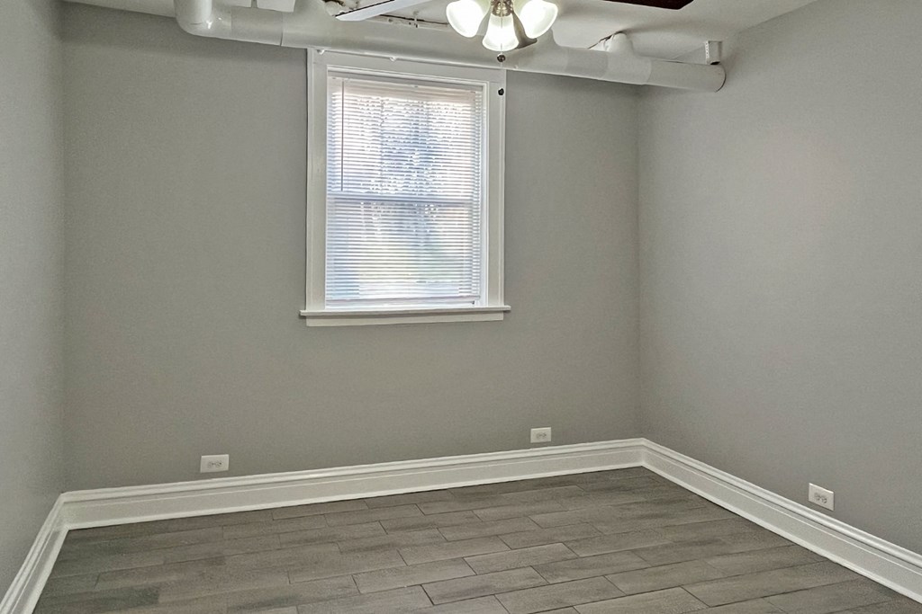 A room with a window and a ceiling fan.