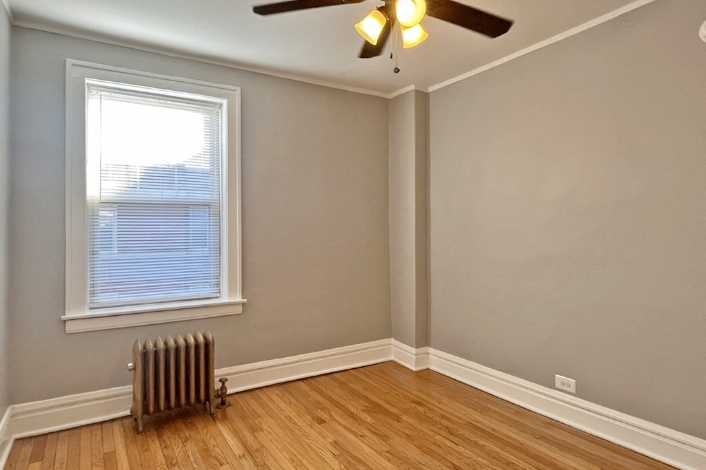 A room with a window and a ceiling fan.