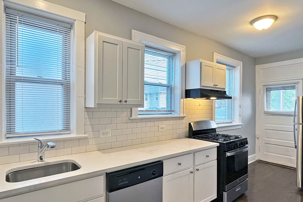 A kitchen with white cabinets and a black stove top oven.