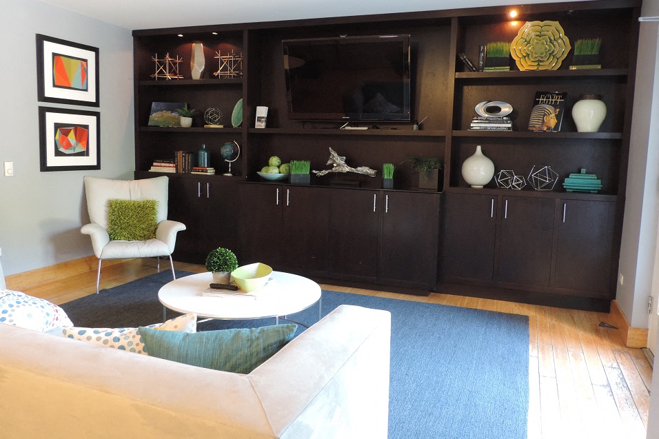 A living room with a white couch and a blue rug.