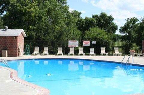 a large swimming pool with chairs around it