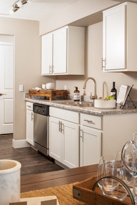 a kitchen with white cabinets and a counter top and a sink