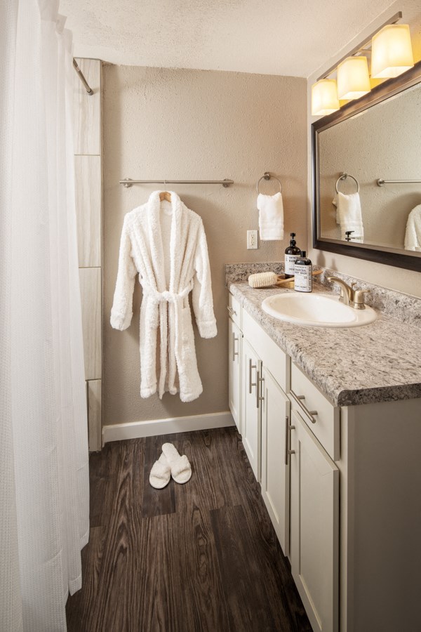 a bathroom with a sink and a robe on the wall