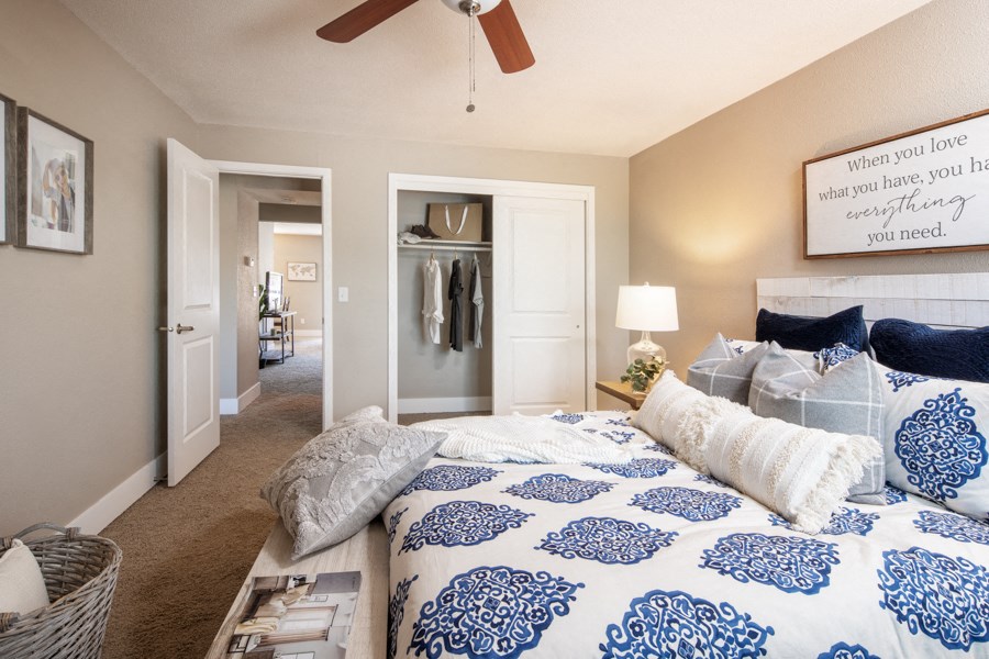 a bedroom with a blue and white bed and a ceiling fan