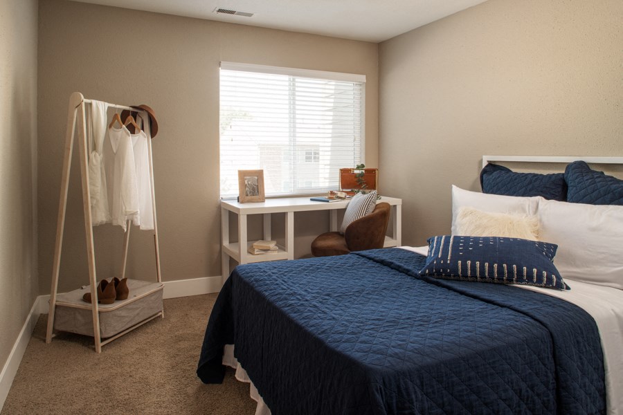a bedroom with a bed and a dresser and a window