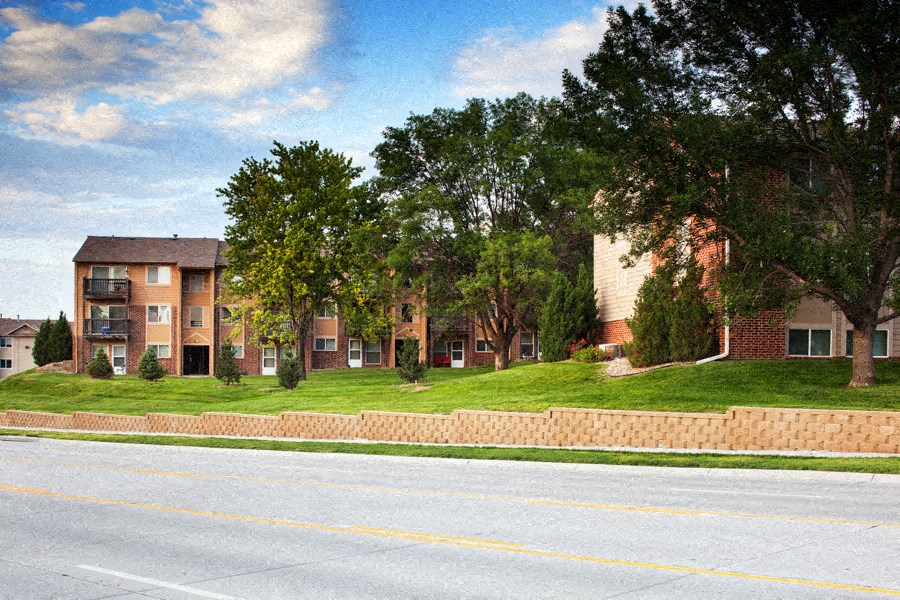 an exterior view of an apartment building on a lawn