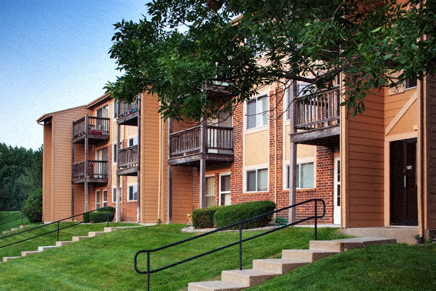 a building with stairs and a tree in front of it
