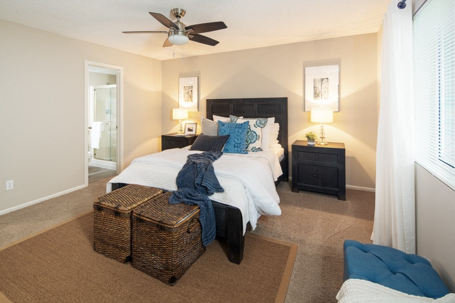 a bedroom with a large bed and a ceiling fan