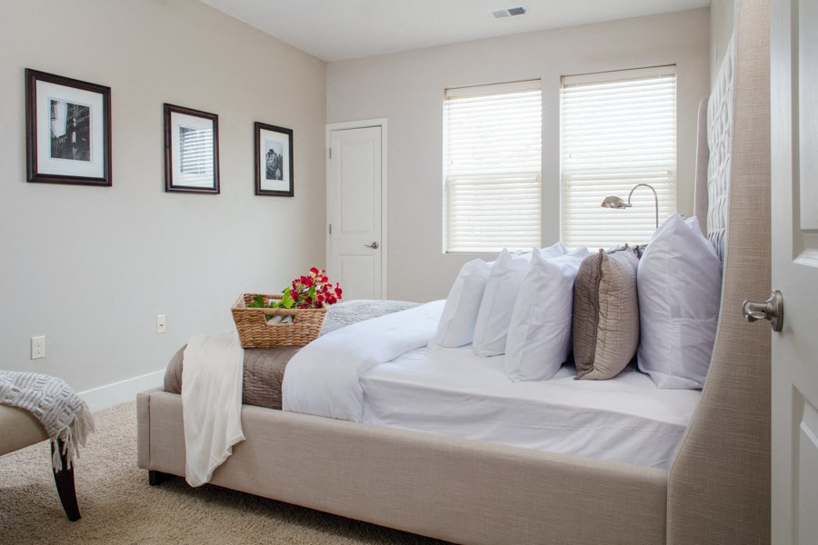 a bedroom with a large bed with white sheets and pillows
