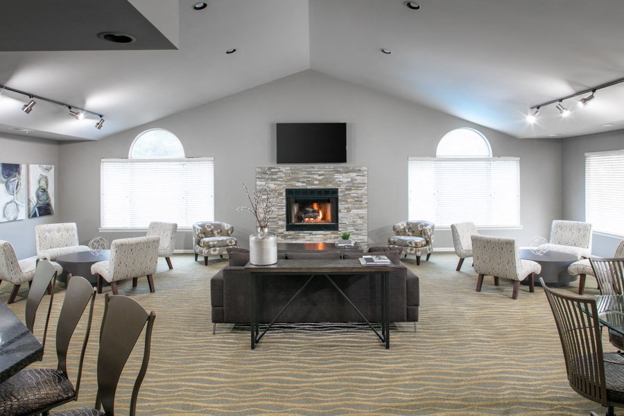 a large living room with a fireplace and tables and chairs