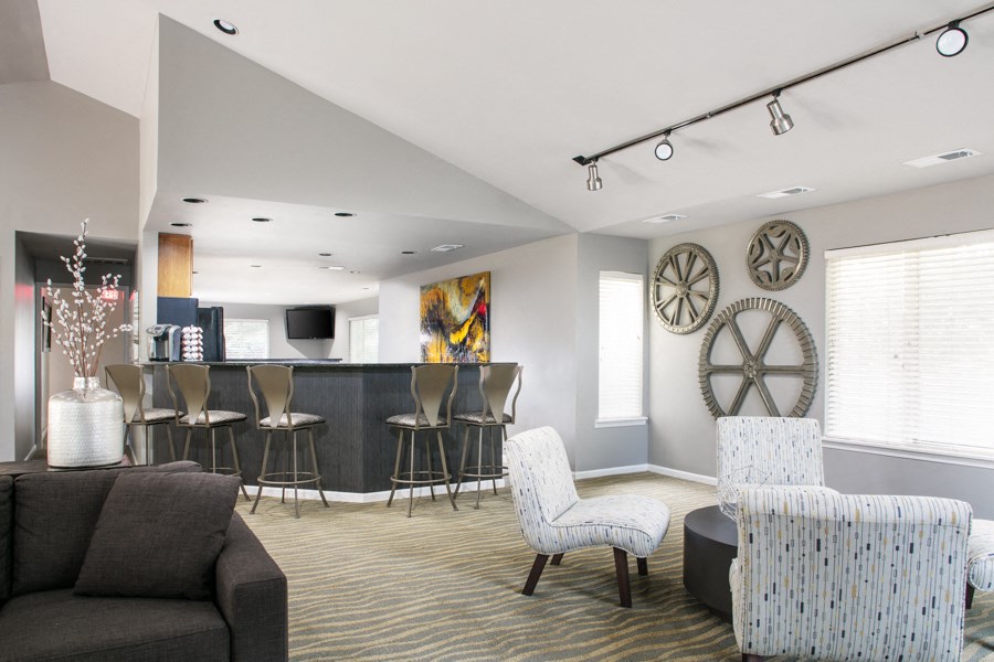 a living room with a bar and chairs and a couch