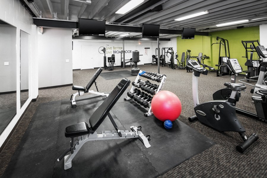 a gym with weights and other exercise equipment on the floor