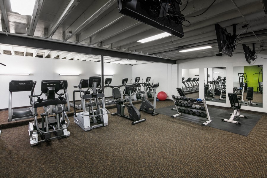 a gym with cardio equipment and weights in a building