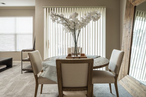 A dining room with a round table and chairs.