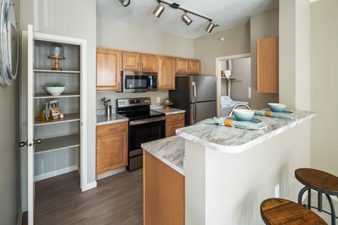 A kitchen with wooden cabinets and a marble countertop.