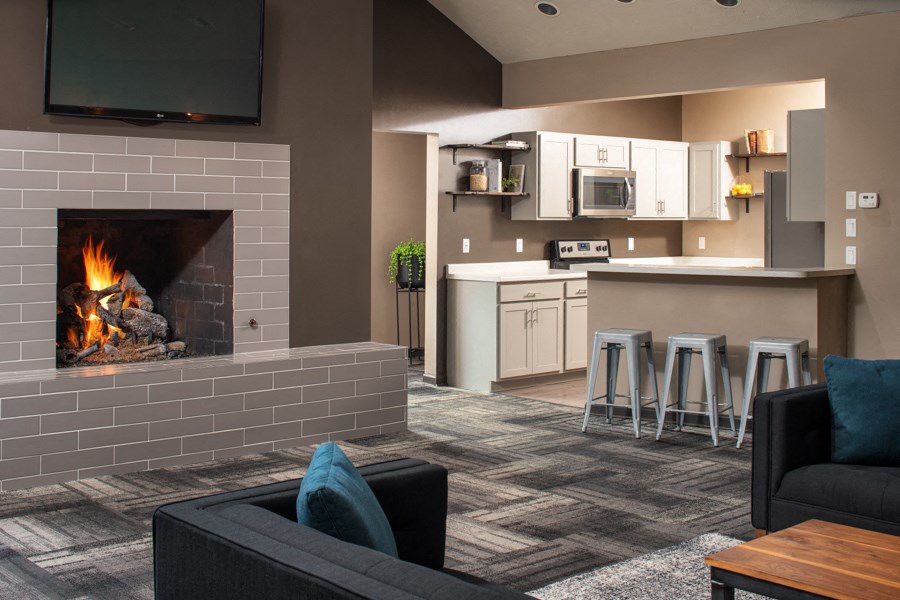 a living room with a fireplace and a kitchen