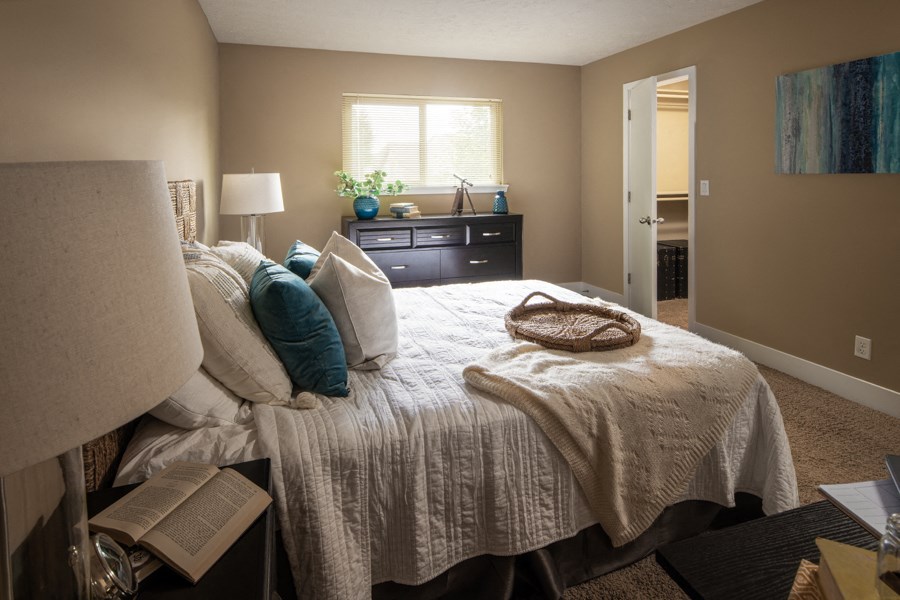 a bedroom with a bed and a dresser and a window