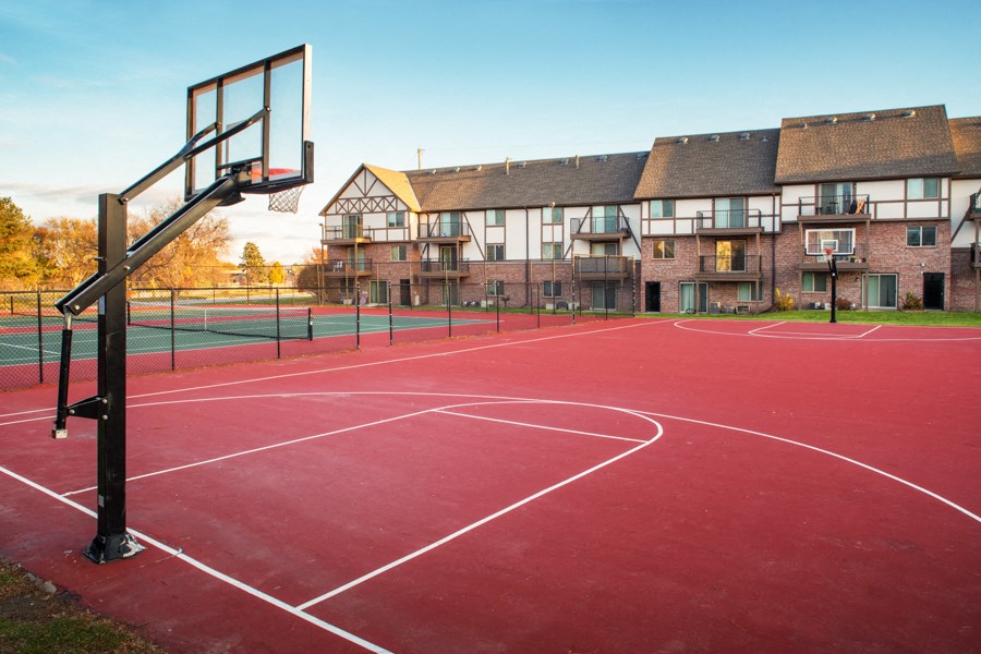 a basketball court in front of an apartment building