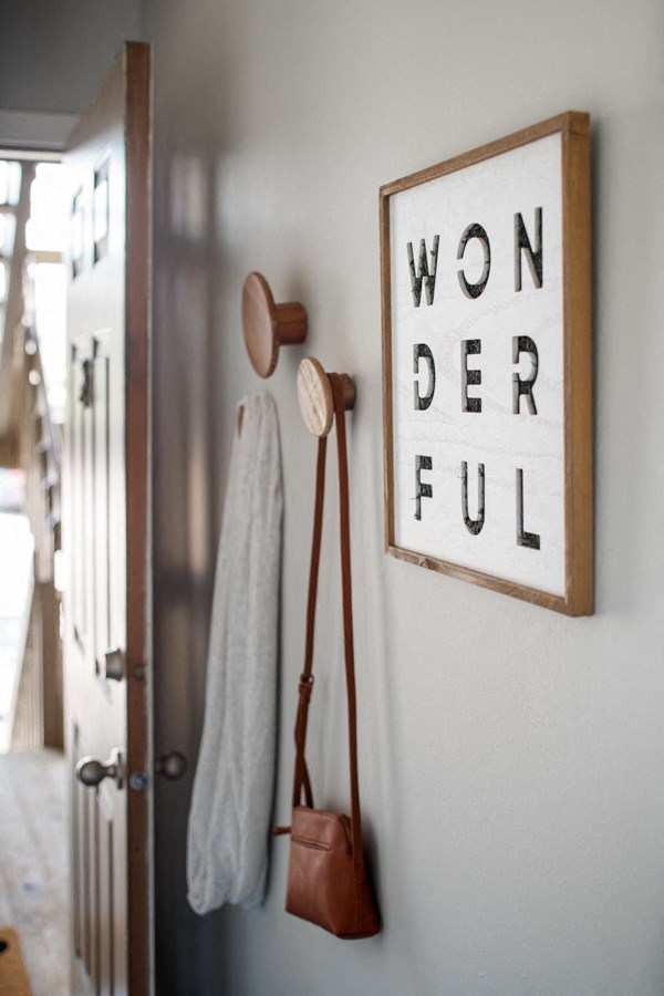 a bathroom with a towel rack and a sign on the wall