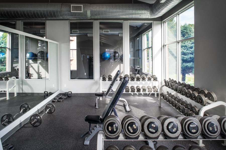 a fitness room with weights and a large window