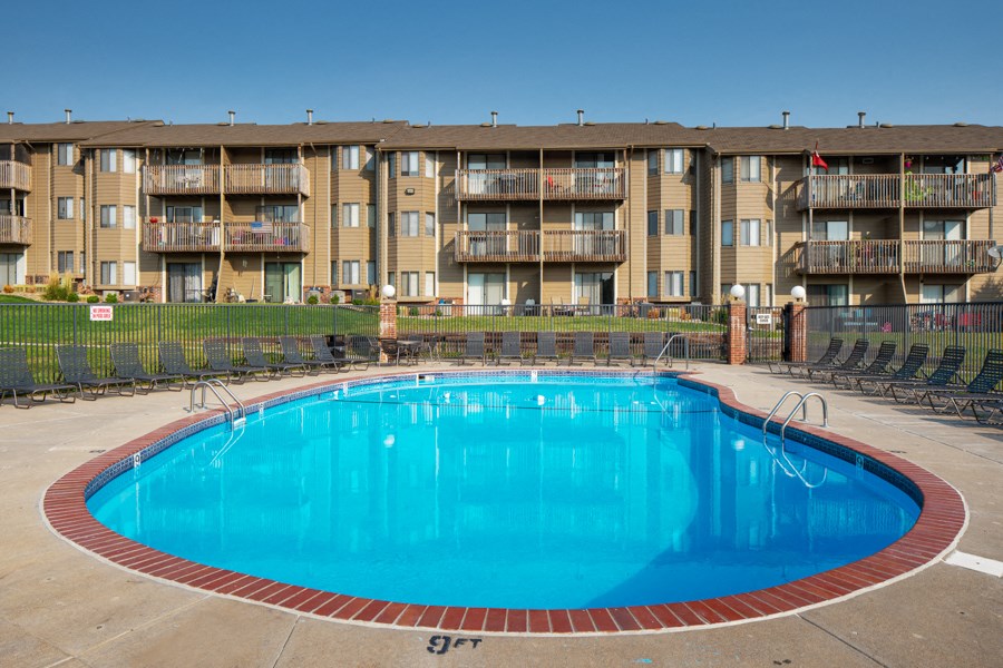 a large blue swimming pool in front of an apartment building