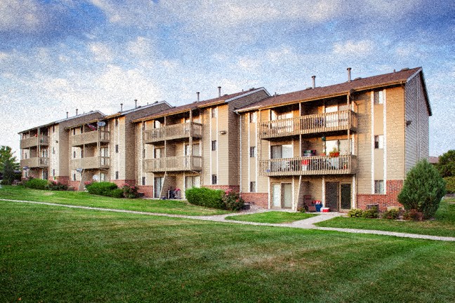 a row of apartment buildings with balconies and a sidewalk