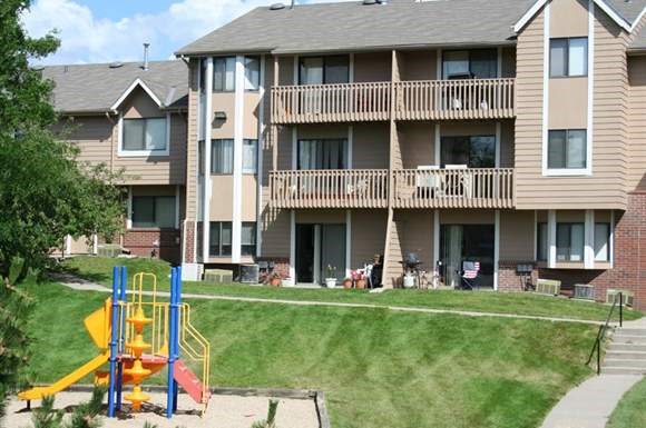 an apartment building with a playground in front of it