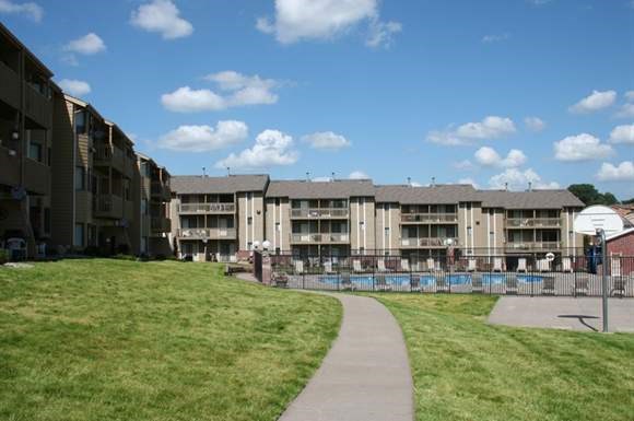 an apartment building with a walkway next to a pool