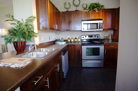 A kitchen with wooden cabinets and a stainless steel oven.