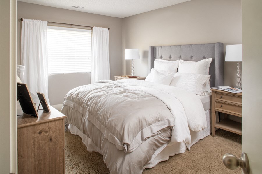 a bedroom with a bed and a dresser and a window